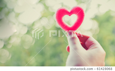 Woman holding pink heart in hands for valentines Woman holding pink heart in hands for valentines 61428068