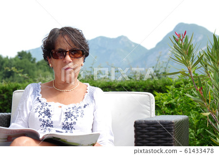 Portrait of  smiling middle age woman sitting in 61433478