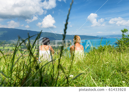 Two women watching  view of Lake Annecy 61433928