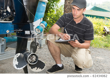 a mechanic checking the boat propeller a mechanic checking the boat propeller 61434062