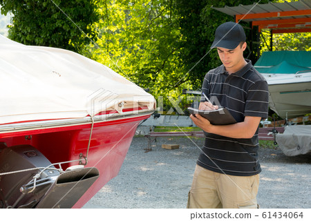 young mechanic checking the motor boat 61434064