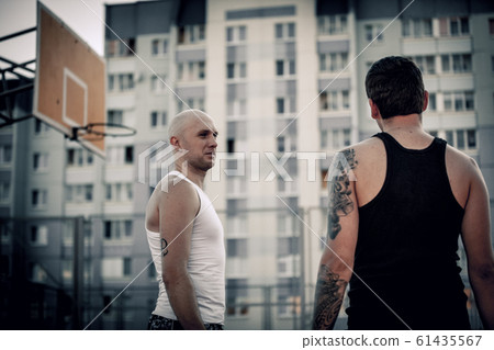 Two guys jump stretch to the ball on the basketball court. Backlight. Sun in the sunset. 61435567