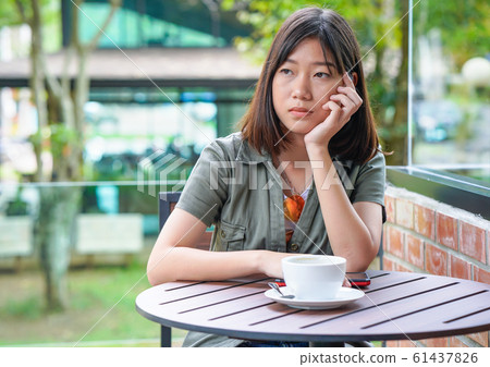 woman sitting in a cafe terrace 61437826