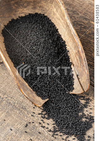 Black cumin seeds spilled from a vintage scoop Black cumin seeds spilled from a vintage scoop 61438583