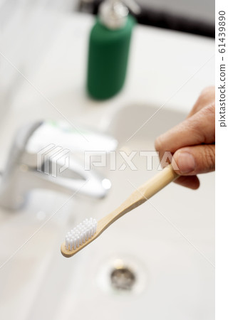 man using a bamboo toothbrush in the bathroom man using a bamboo toothbrush in the bathroom 61439890
