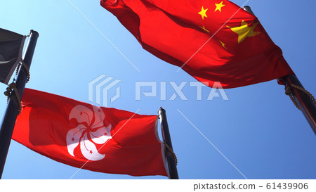 Hong Kong and Mainland China red flags in blue sky. Internal political affair conflict issue Hong Kong and Mainland China red flags in blue sky. Internal political affair conflict issue 61439906