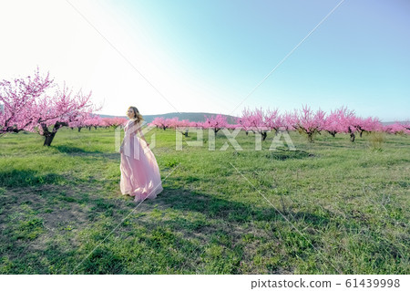 Woman in a long wedding dress in the garden 61439998