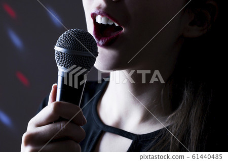 Close up of attractive girl holding microphone and 61440485