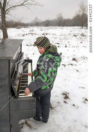 Boy playing piano outdoors 61441337