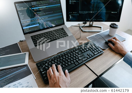 Programmer Typing Code on desktop computer, 61442179