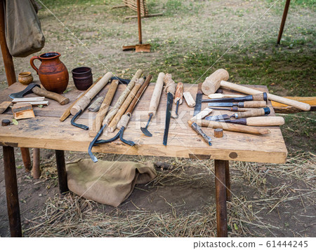 Old woodworking hand tool: wooden plane, chisel ax, sledgehammer, hammer and in a carpentry workshop on dirty rustic table covered with sawdust background side view Old woodworking hand tool: wooden plane, chisel ax, sledgehammer, hammer and in a carpentry workshop on dirty rustic table covered with sawdust background side view 61444245