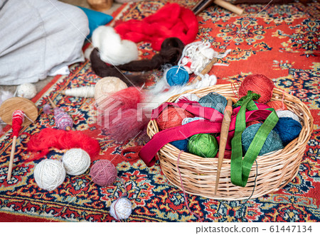 Close up colorful yarn in basket red, rose, blue, green, coiled in ball skein on wolen carpet. Knitting and crochet, hand craft work. Natural wool different color combination Close up colorful yarn in basket red, rose, blue, green, coiled in ball skein on wolen carpet. Knitting and crochet, hand craft work. Natural wool different color combination 61447134