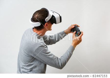 Man with virtual reality headset is playing game. 61447153