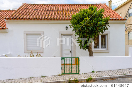 A small white house with red tiles 61448647
