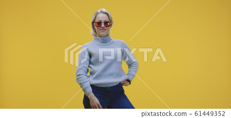 Young woman putting on sunglasses 61449352