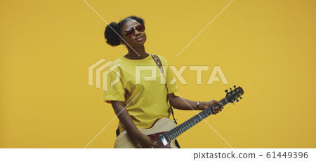 Young woman playing electric guitar Young woman playing electric guitar 61449396