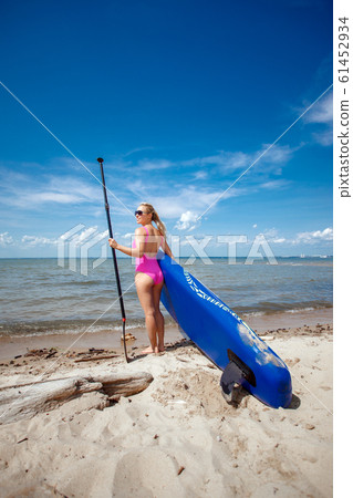 Young beautiful woman in a bright pink bikini 61452934