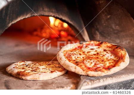 Baked tasty margherita pizza in Traditional wood oven in Naples restaurant, Italy. Original neapolitan pizza. Red hot coal. 61460326