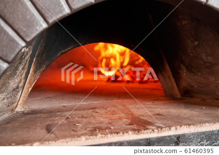 Firewood is burning, the stove is being heated. Red hot coal. Traditional wood oven in Naples restaurant, Italy. Original neapolitan pizza. Firewood is burning, the stove is being heated. Red hot coal. Traditional wood oven in Naples restaurant, Italy. Original neapolitan pizza. 61460395