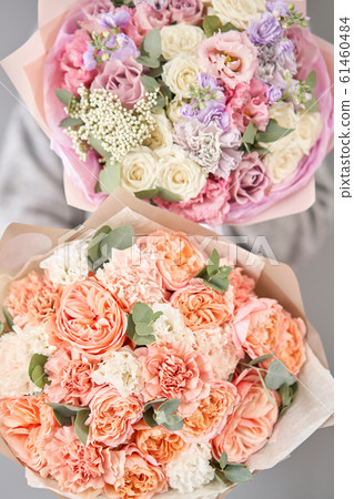 Two Beautiful bouquets of mixed flowers in womans hands. the work of the florist at a flower shop. Delivery fresh cut flower. European floral shop. Two Beautiful bouquets of mixed flowers in womans hands. the work of the florist at a flower shop. Delivery fresh cut flower. European floral shop. 61460484