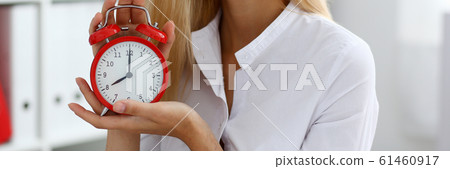 Smiling business woman holding in hand on the alarm Smiling business woman holding in hand on the alarm 61460917