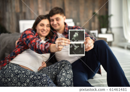 Beautiful pregnant couple in the bedroom. Preparing for childbirth, happy parents, waiting for the first child. Support for women before childbirth. Beautiful pregnant couple in the bedroom. Preparing for childbirth, happy parents, waiting for the first child. Support for women before childbirth. 61461481