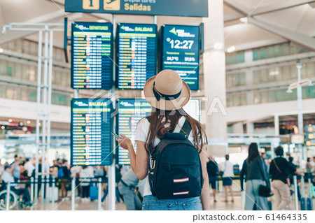 at the airport the girl looks at the scoreboard 61464335