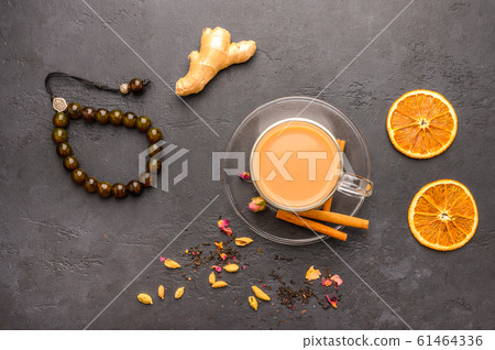 Traditional Indian masala tea chai. Cinnamon, anise, cardamom, sugar next to a black textured 61464336