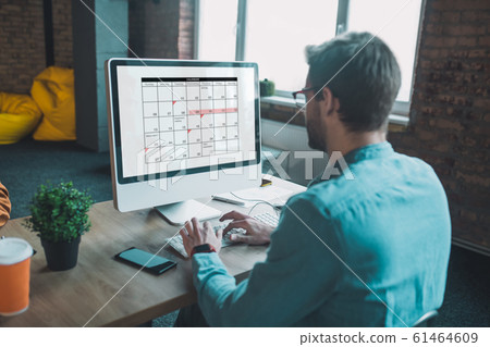 Nice smart man looking at the calendar 61464609