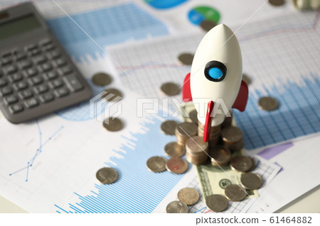 Small toy rocket, coins, calculator and official documents at business desk Small toy rocket, coins, calculator and official documents at business desk 61464882
