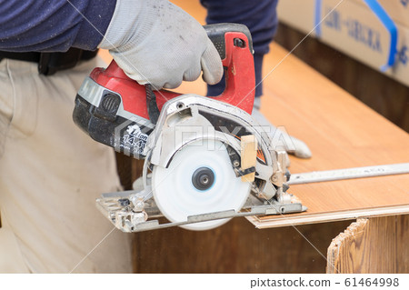 切開與電圓鋸的地板的工匠的手的特寫鏡頭 切開與電圓鋸的地板的工匠的手的特寫鏡頭 61464998