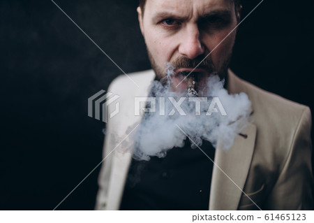 Angry Man Exhaling Cigar Smoke at Camera Angry Man Exhaling Cigar Smoke at Camera 61465123