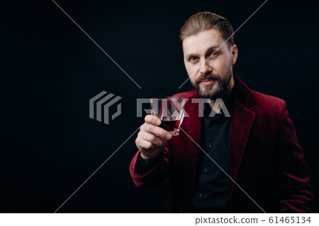 Stylish Man in Vinous Jacket Toasting With a Glass of Spirits 61465134