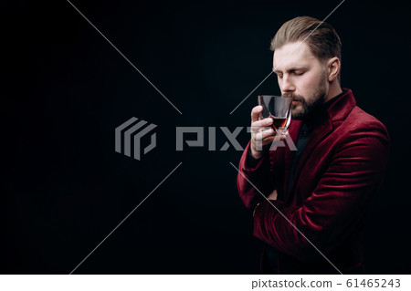 Bearded Brown-haired Man in Velvet Jacket Smelling Whiskey 61465243