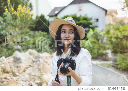 Young asian woman in a park holding camera, outdoor portrat 61465458
