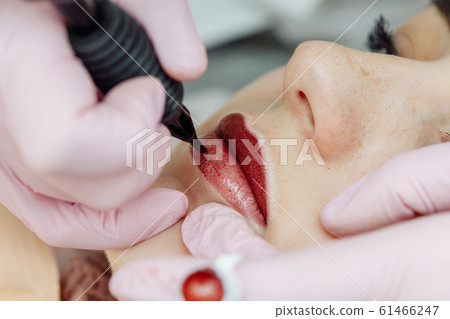 Woman having permanent makeup on lips Woman having permanent makeup on lips 61466247