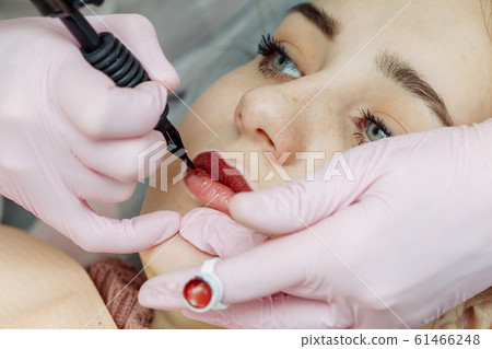 Woman having permanent makeup on lips Woman having permanent makeup on lips 61466248