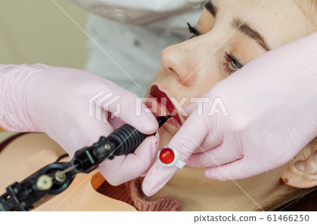 Woman having permanent makeup on lips Woman having permanent makeup on lips 61466250