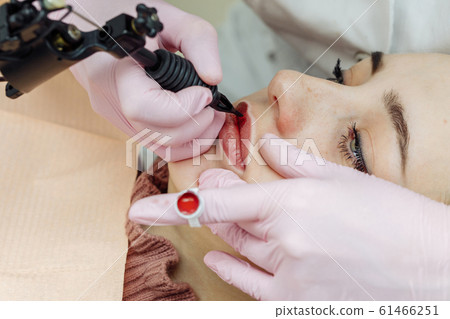 Woman having permanent makeup on lips 61466251