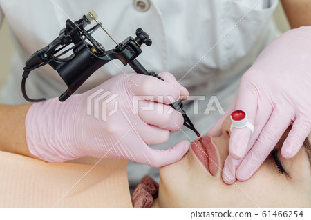 Woman having permanent makeup on lips Woman having permanent makeup on lips 61466254
