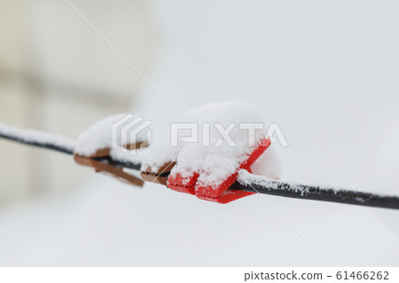 Clothespins on clothesline covered with snow Clothespins on clothesline covered with snow 61466262