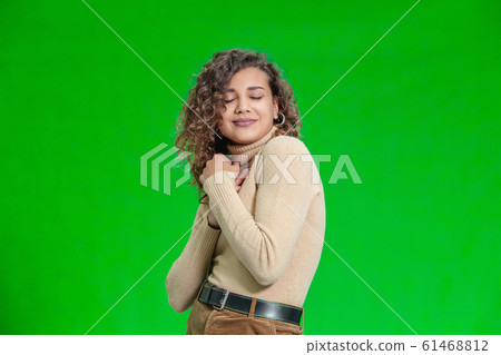 Gift of a dream concept. Excited female holds new phone close to her chest, rejoicing her new present. 61468812