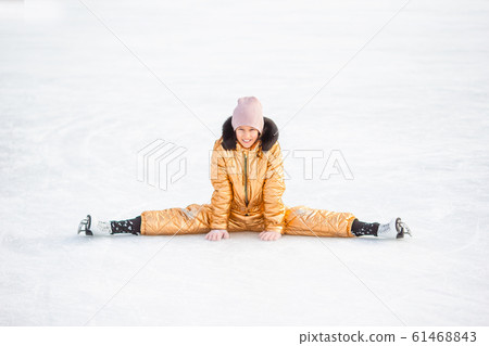 Little adorable girl sitting on ice with skates after fall Little adorable girl sitting on ice with skates after fall 61468843