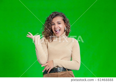 Hello everyone. Portrait of confident attractive and self-assured female waving her hand, smiling friendly over green background. Hello everyone. Portrait of confident attractive and self-assured female waving her hand, smiling friendly over green background. 61468888