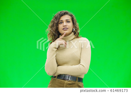 Thoughtful girl in casual clothes, keeping finger on cheek, looking lost in thoughts. Thoughtful girl in casual clothes, keeping finger on cheek, looking lost in thoughts. 61469173