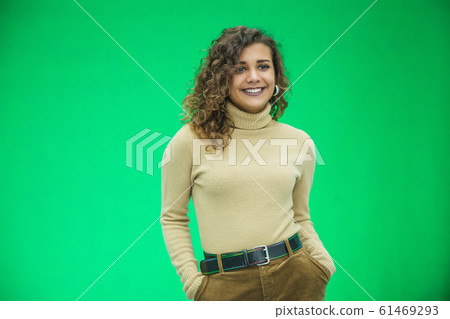 Glowing girl posing on green background, looking positive, smiling. Glowing girl posing on green background, looking positive, smiling. 61469293