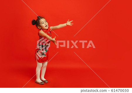 Happy Chinese New Year. Asian little girl portrait isolated on red background Happy Chinese New Year. Asian little girl portrait isolated on red background 61470030