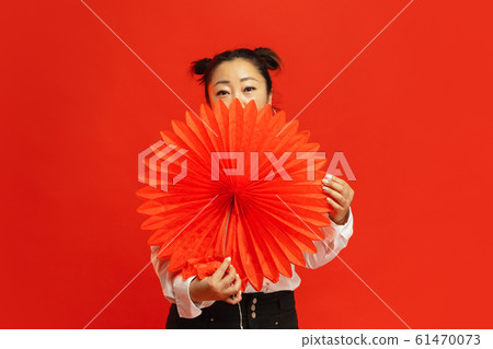 Happy Chinese New Year. Asian young woman portrait isolated on red background Happy Chinese New Year. Asian young woman portrait isolated on red background 61470073