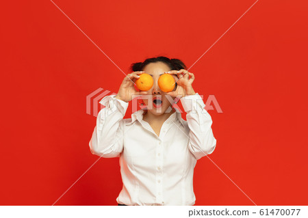 Happy Chinese New Year. Asian young woman portrait isolated on red background Happy Chinese New Year. Asian young woman portrait isolated on red background 61470077