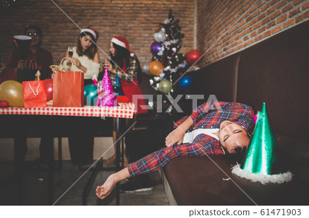 picture of Asian man are very drunk and sleeping on the sofa with his friend are drinking champagne at the party. concept of Xmas party, Christmas party and New year party celebration. picture of Asian man are very drunk and sleeping on the sofa with his friend are drinking champagne at the party. concept of Xmas party, Christmas party and New year party celebration. 61471903